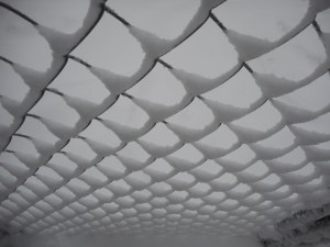 the wind  carrying some snow right through the fence... 