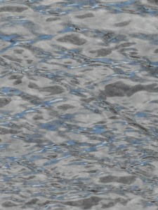 wind ripples the puddle filled with sky