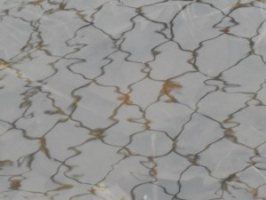 chain link fence ripples in reflection on a puddle