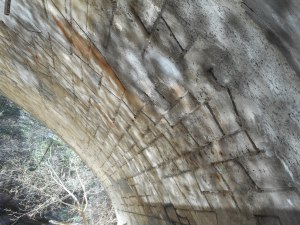 daydream play of sun off the water on the underside of the old stone bridge