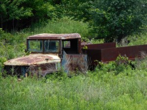 wind running through the field around the old truck